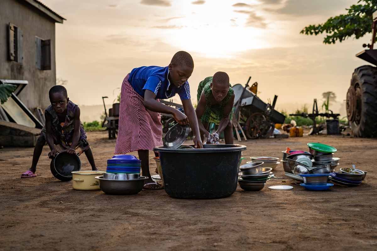 children washing dishes outside